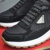 Pradasneakers_3_f4763a97-687d-43e5-b2b1-77efb6a08eb3 Prada Prax 2.0 Re-Nylon and Suede Sneaker in a black and white colorway.