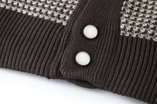 The jacket is brown and beige with a houndstooth-like pattern across the main body, and has solid, dark brown sleeves with a different knit texture
