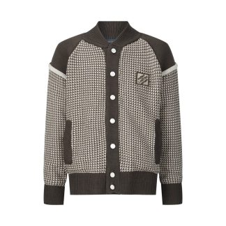 The jacket is brown and beige with a houndstooth-like pattern across the main body, and has solid, dark brown sleeves with a different knit texture