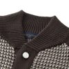 The jacket is brown and beige with a houndstooth-like pattern across the main body, and has solid, dark brown sleeves with a different knit texture
