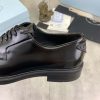 Prada black patent-leather derby shoe.