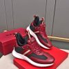 A pair of Bally Mixed-Material Runner Sneakers in burgundy and black resting on top of a red Bally shoebox.
