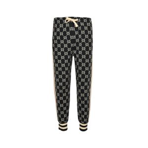 Front view of dark navy and ivory Gucci GG jacquard track pants featuring an elastic drawstring waist and striped ribbed ankle cuffs.