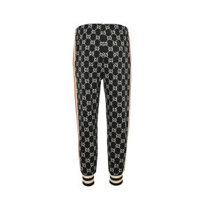 Back view of Gucci monogram track pants demonstrating a continuous GG pattern and tapered ankle silhouette.